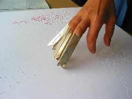 Dominique De Beir bewerkt papier met zilveren opzetstukken voor op de vingers; foto PHŒBUS•Rotterdam
PHŒBUS•Rotterdam