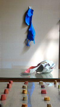 Stefan Gritsch, aan wand, ''Michkanne'', 2009, hangend, acrylverf, linnen, 90 x 22 x 15 cm.; op tafel, ''Milchkanne'', 2007, acrylverf, grondering, linnen [melkkan 2 ltr. en afdruk] en installatie met afgietsels uit mergpijpen in aardpigmenten/beenderlijm/lijnolie/hars.
PHŒBUS•Rotterdam